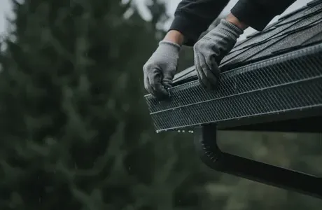 Gutter guard installed along a roof edge